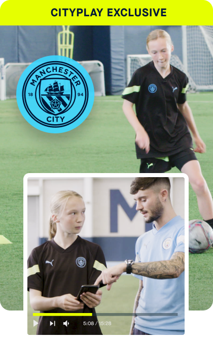 Two people on a soccer field with Manchester City logo and text.